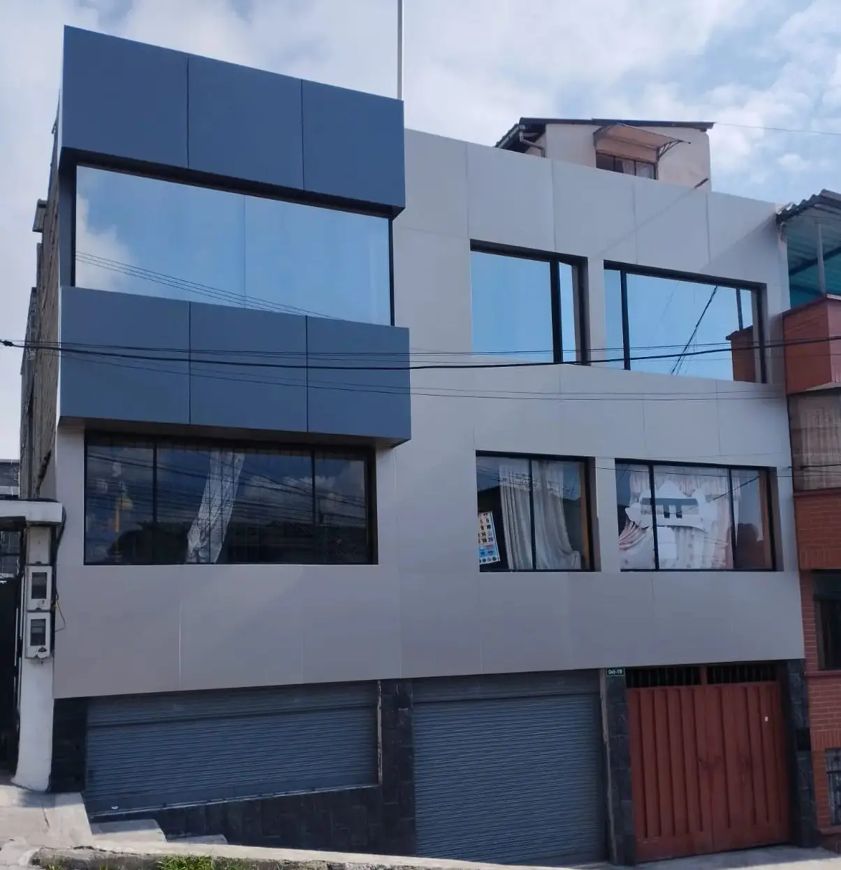 Fachada de Alucobond gris y azul en edificio de tres plantas