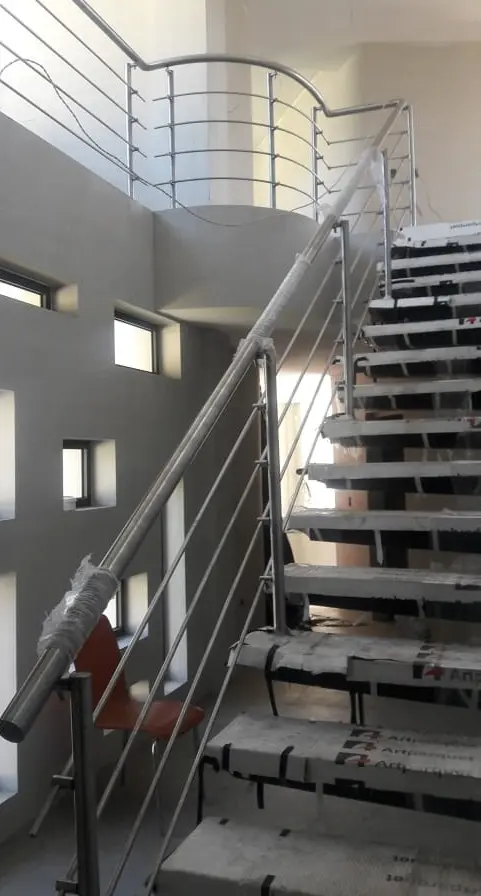 Pasamanos de acero inoxidable con accesorios en escalera curva, instalado en Quito