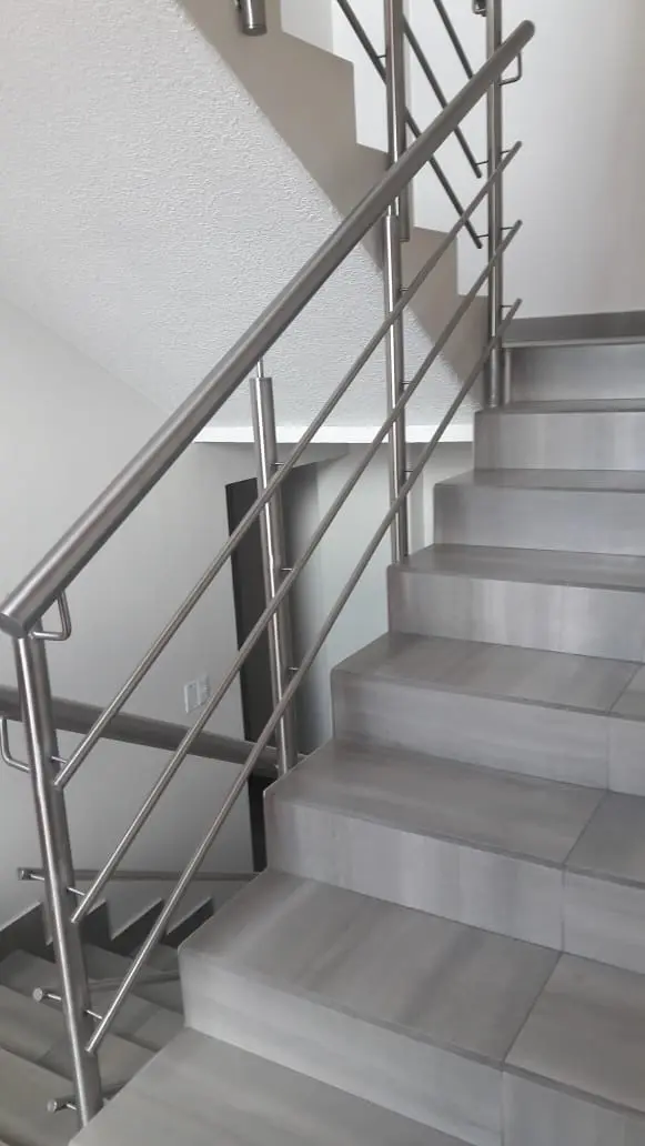Pasamanos de acero inoxidable en escalera de peldaños grises