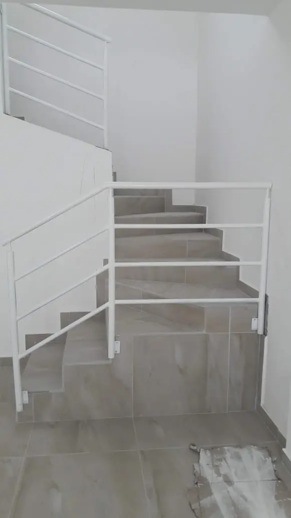 Pasamanos de hierro blanco en escalera de interior
