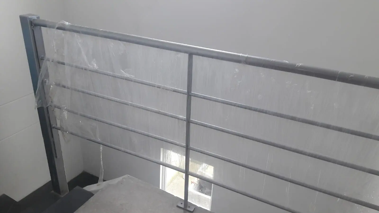 Pasamanos de hierro gris en tramo recto sobre muro