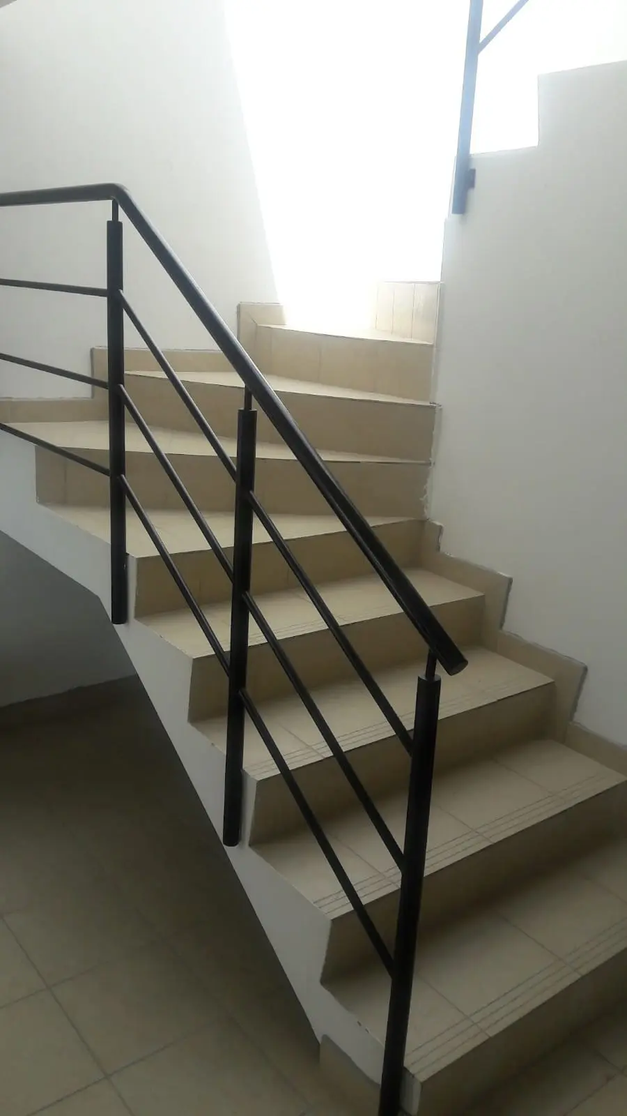 Pasamanos de hierro negro sencillo sobre gradas de vivienda