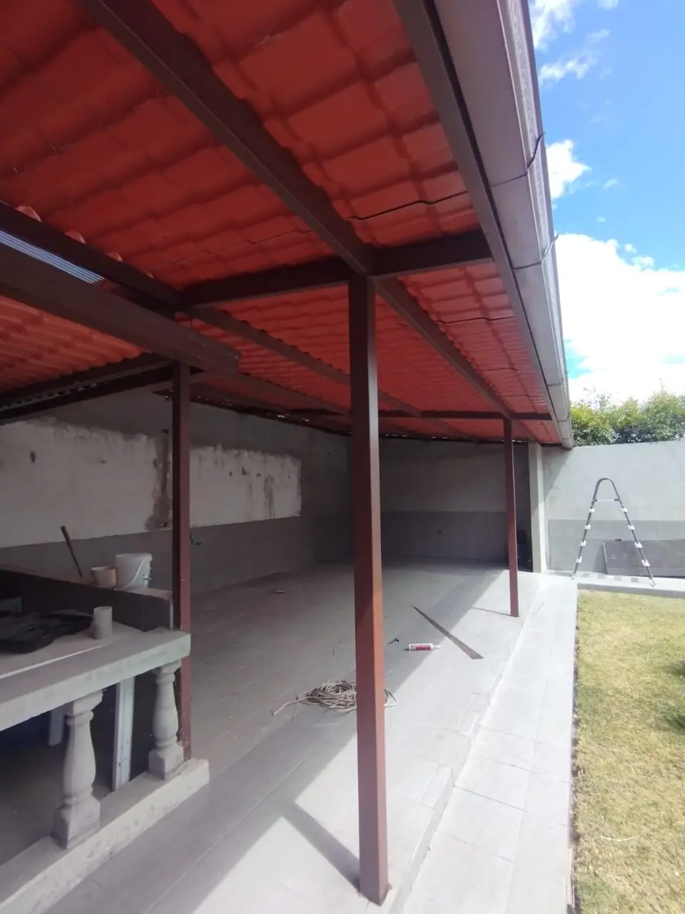Estructura metálica con cubierta roja sobre corredor