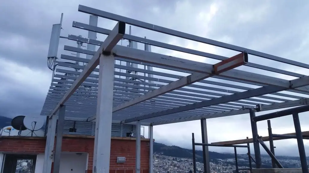 Estructura de vigas metálicas en terraza con vista a la ciudad