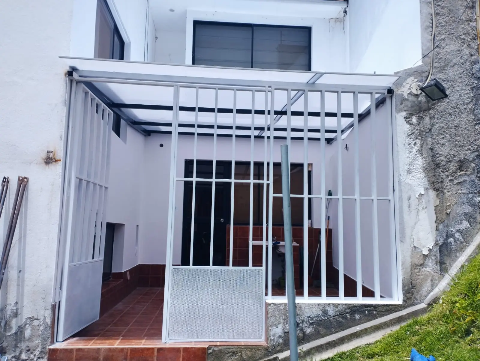 Cubierta de policarbonato sencilla sobre entrada de vivienda