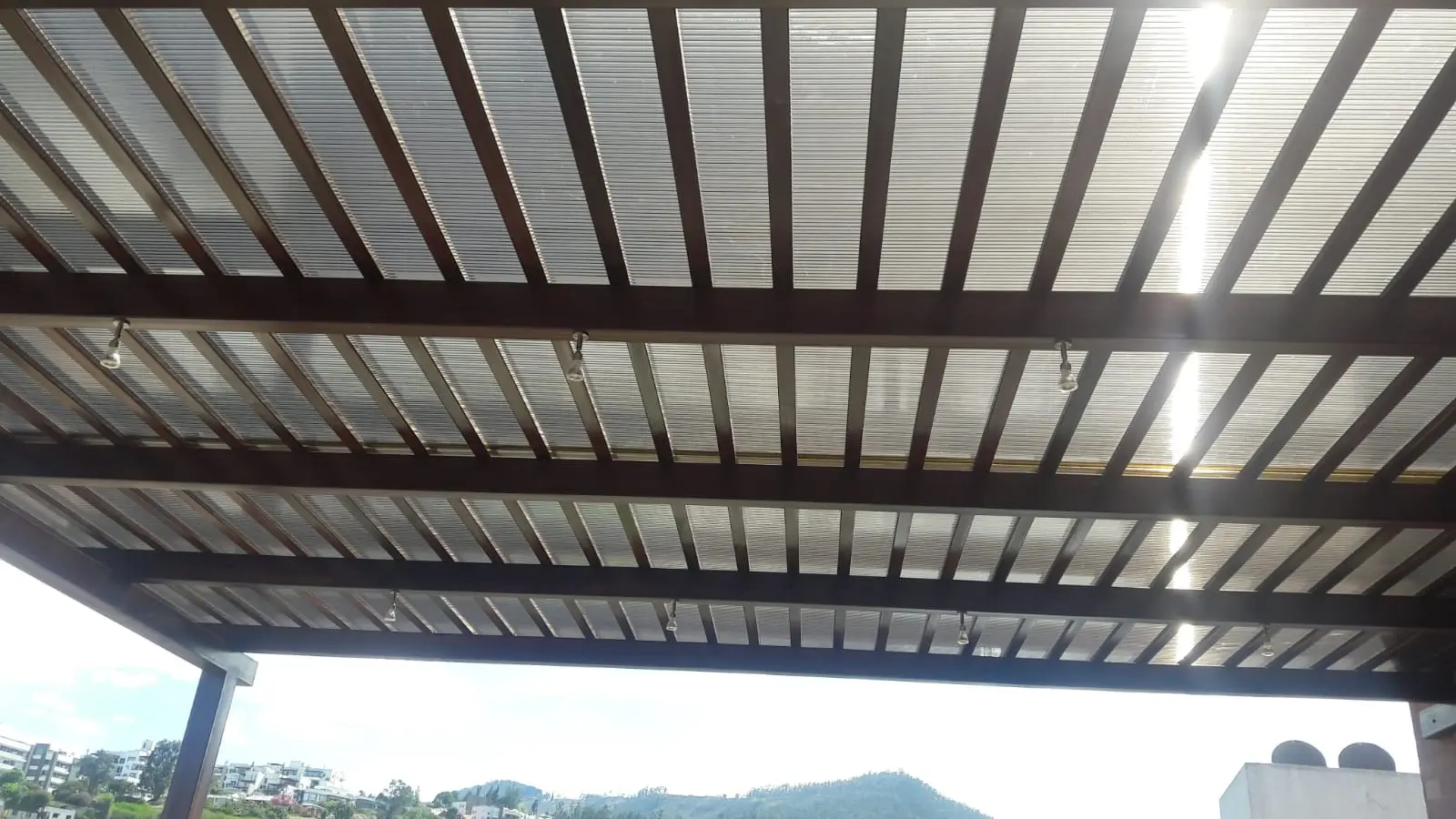 Pérgola de aluminio con policarbonato y listones vista desde abajo