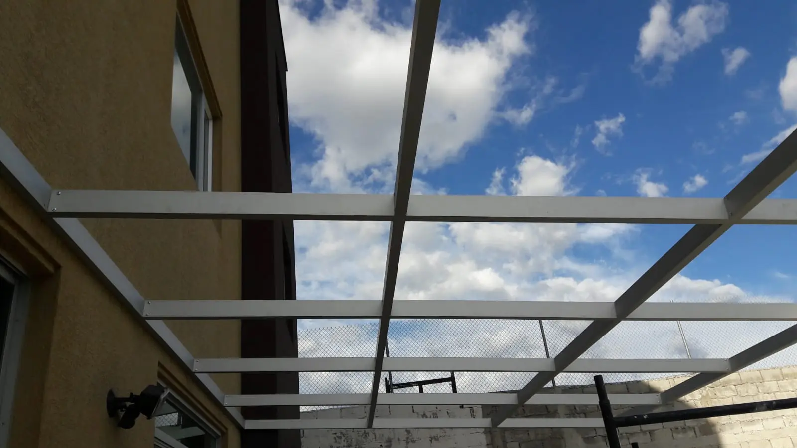 Pérgola con policarbonato y estructura metálica blanca