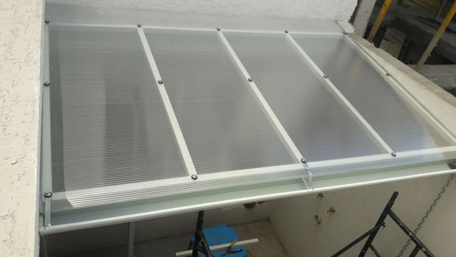 Pérgola de policarbonato traslúcido con perfilería blanca