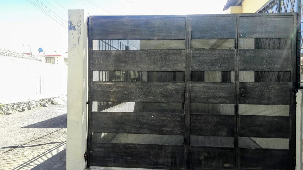 Portón metálico microperforado color negro en Quito