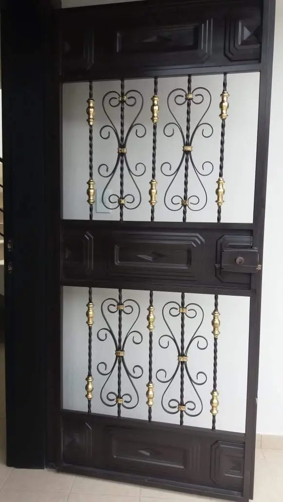 Cubre-puerta de hierro negro con volutas y detalles dorados