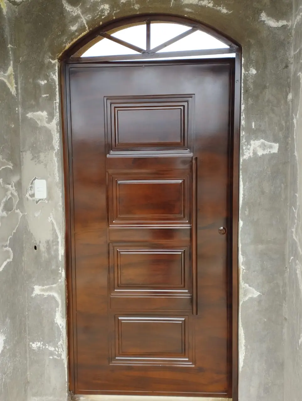 Puerta metálica peatonal con acabado imitación madera y arco superior, a medida en Quito