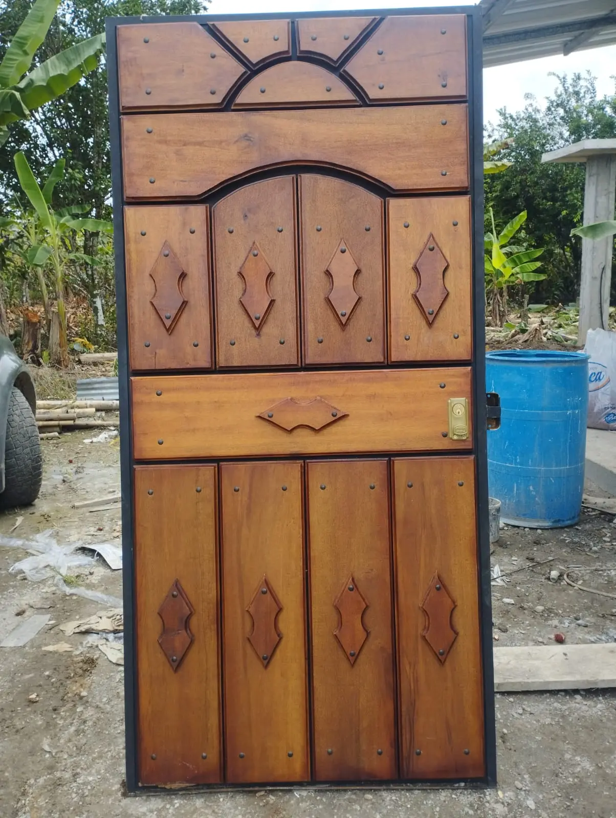 Puerta mixta de madera con tableros y aplicaciones de hierro