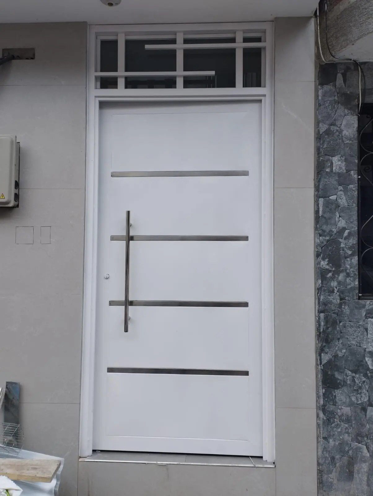 Puerta tamborada blanca con franjas horizontales y montante superior