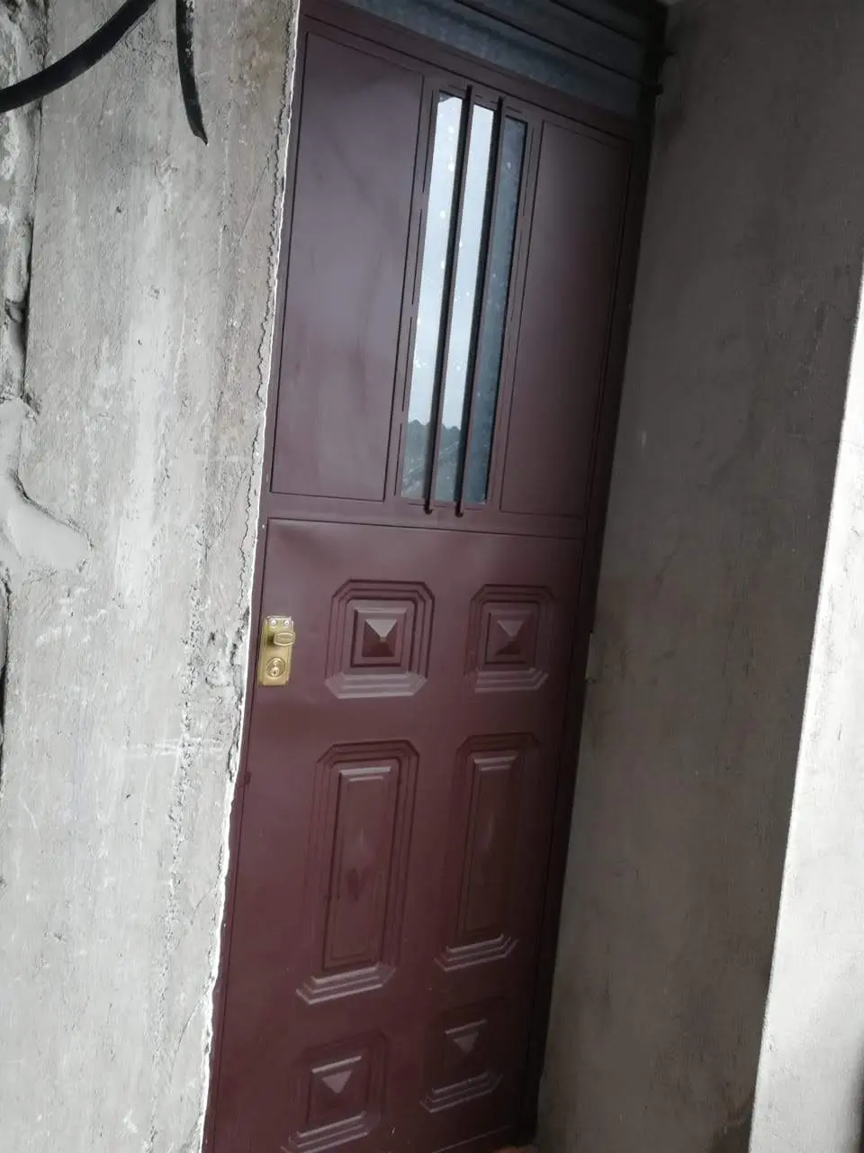 Puerta de tool color granate con tableros y vidrio alargado