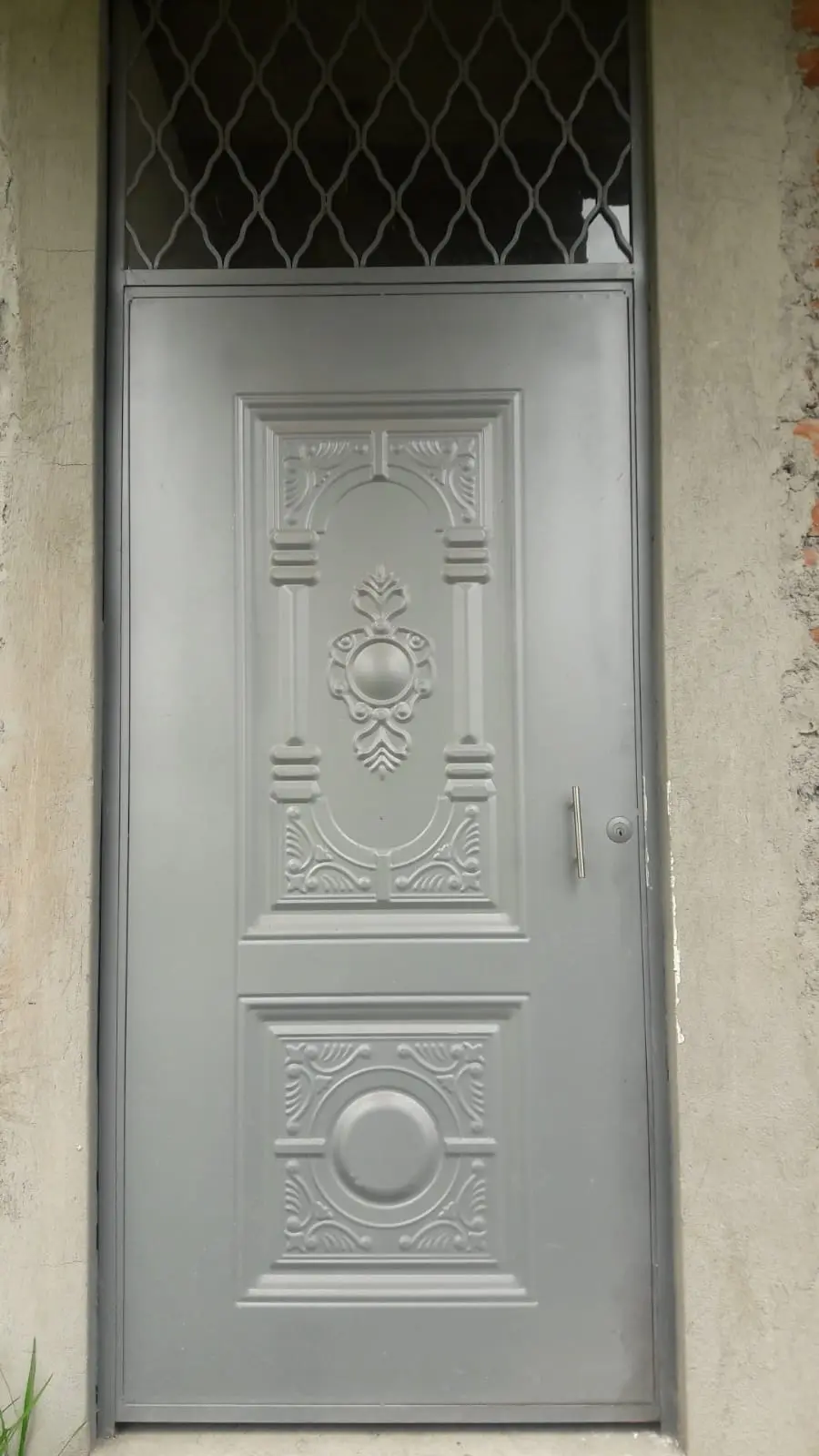 Puerta de tool plateada con tablero decorativo y reja superior de rombos