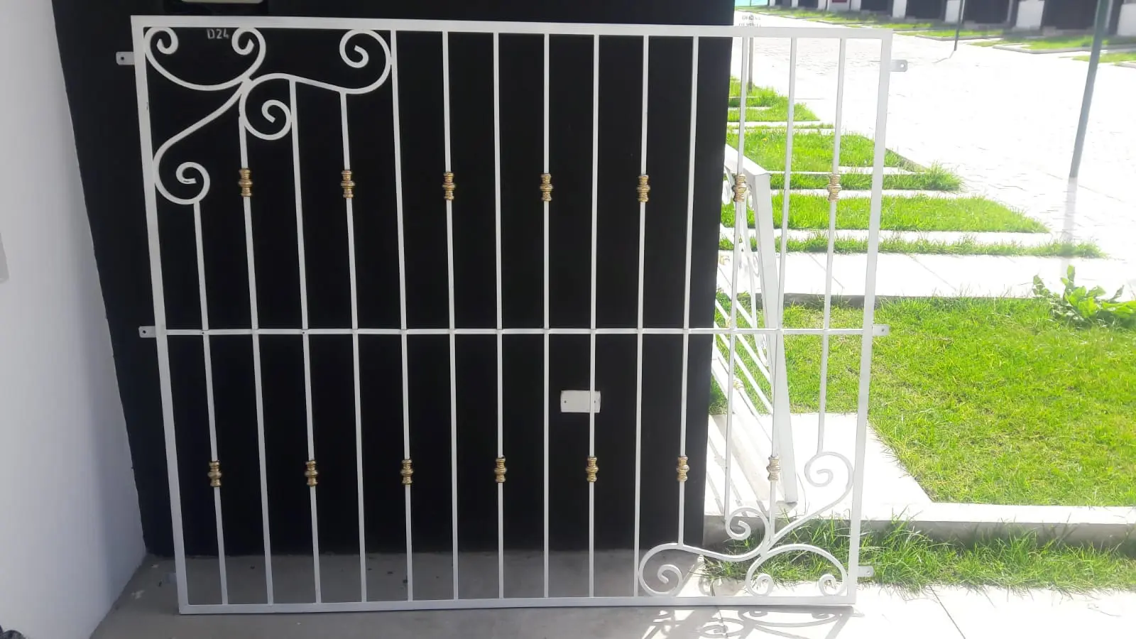 Cubre-ventana blanco con volutas en fachada exterior