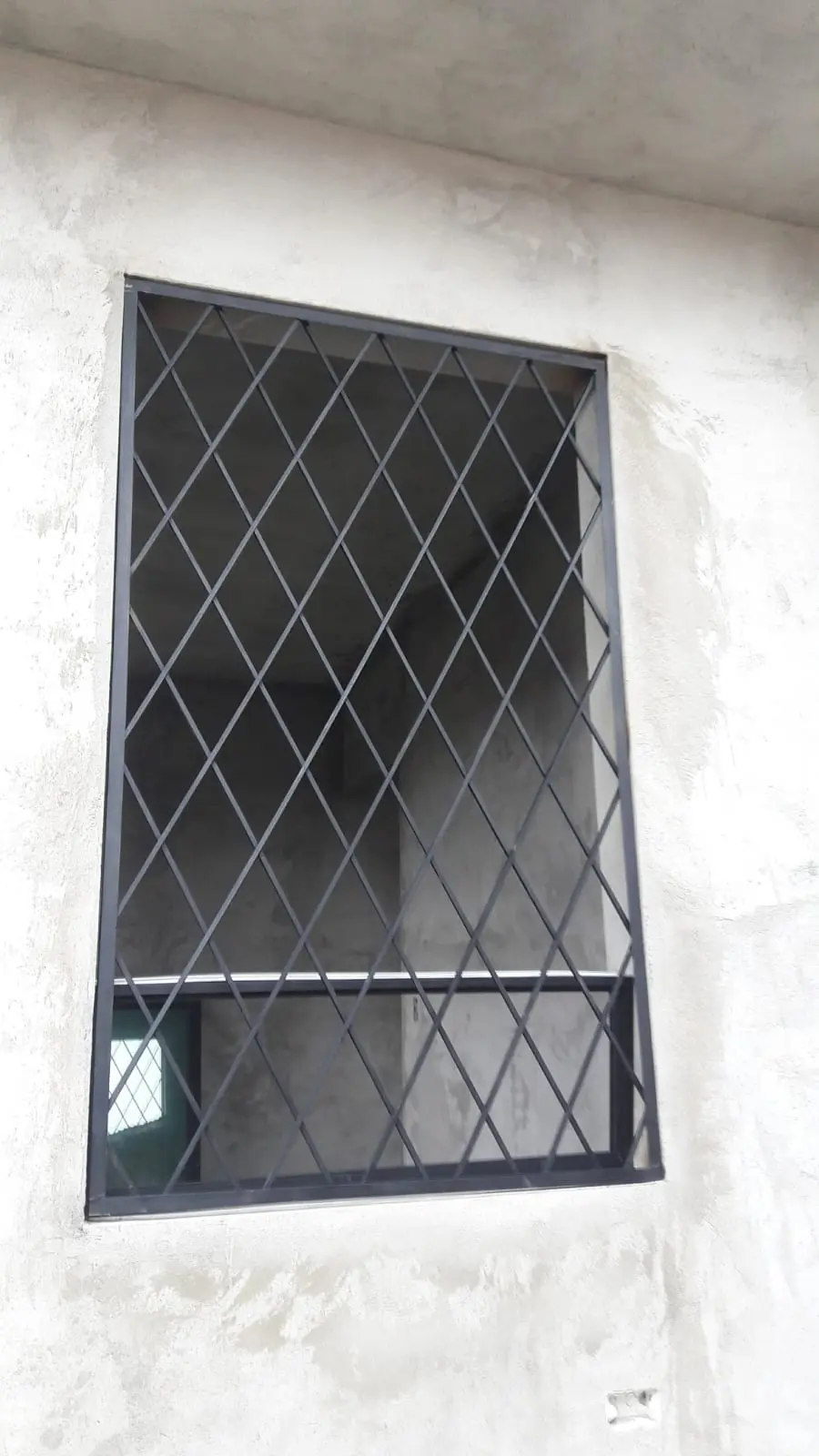 Cubre-ventana negro de rombos en ventana estrecha