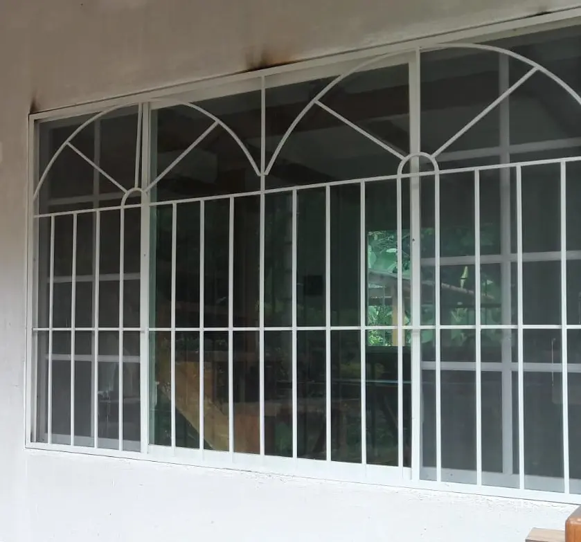 Protector de ventana blanco con arcos sobre un ventanal amplio