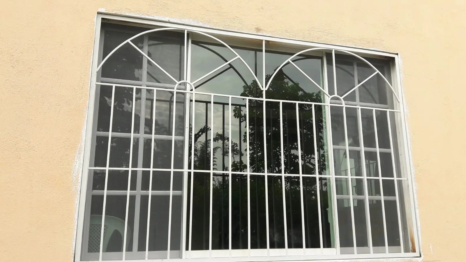 Protectores de ventanas blancos con arcos decorativos en Quito