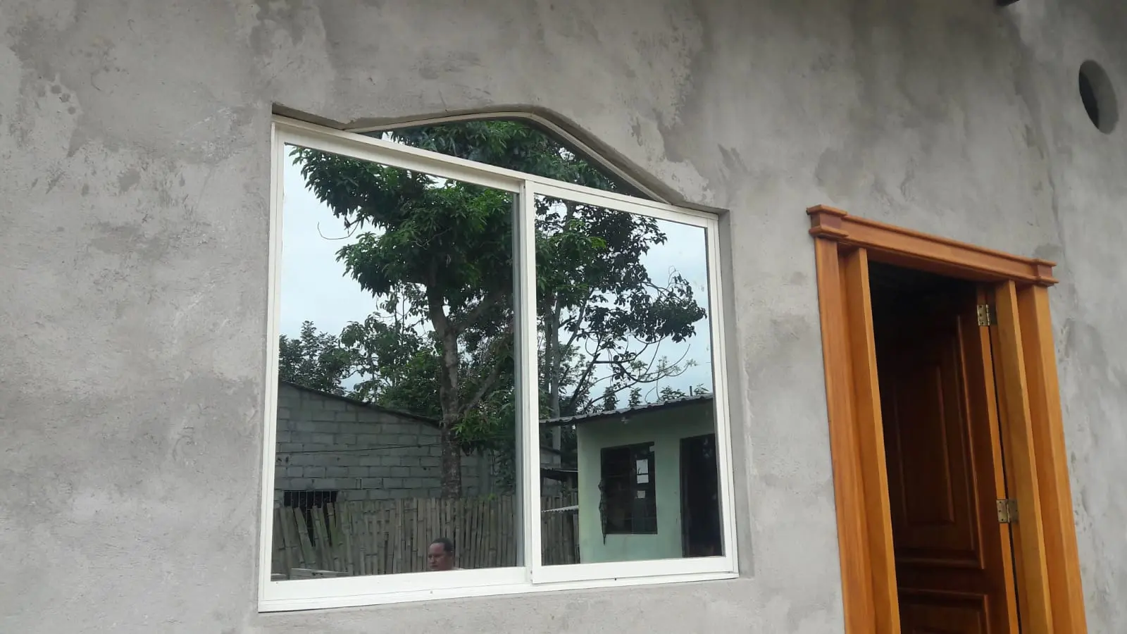 Ventana de aluminio blanca con montante superior en obra